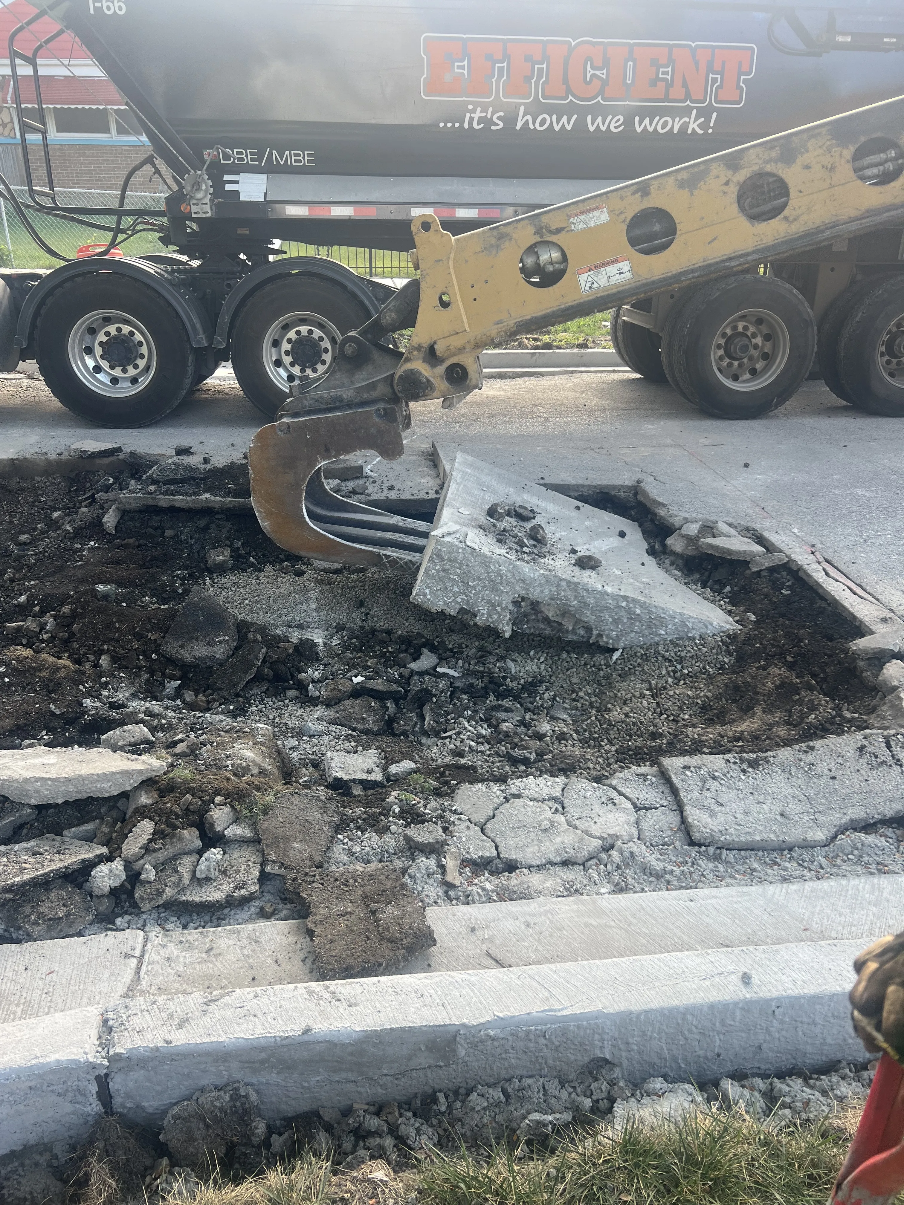 Excavation equipment breaking up an old concrete surface.