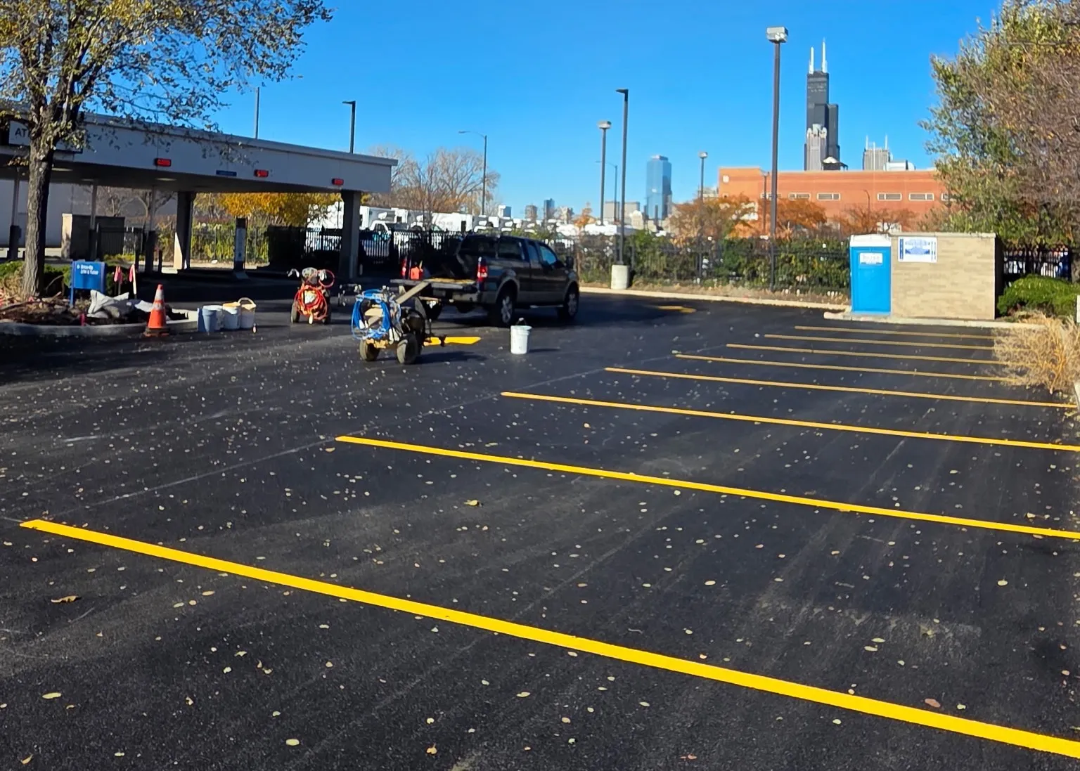 A freshly paved and striped parking lot with the Sears Tower in the background.