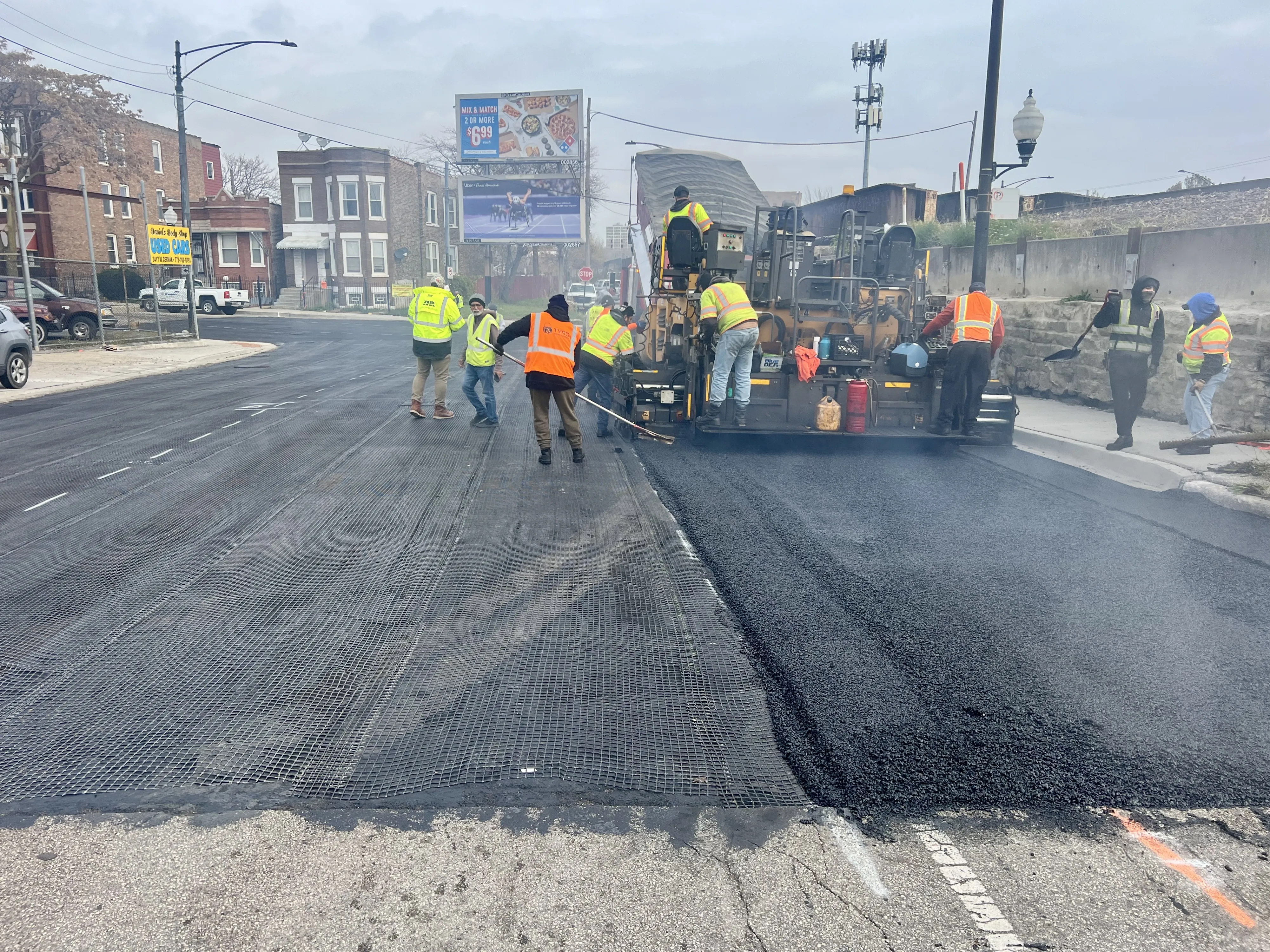 A Northlake paving crew on a public road with the Chicago skyline in the background.