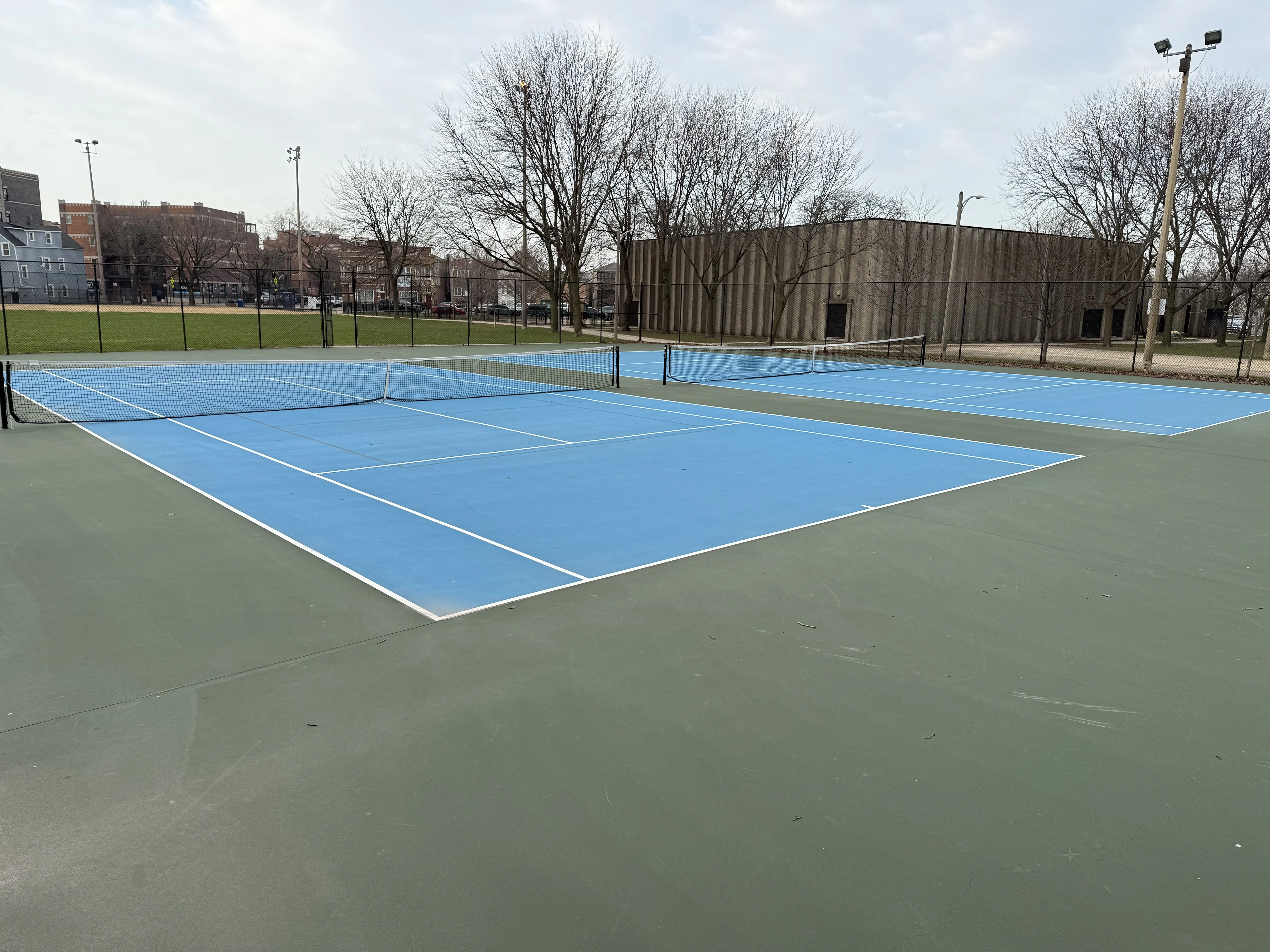 A tennis court in a city park.
